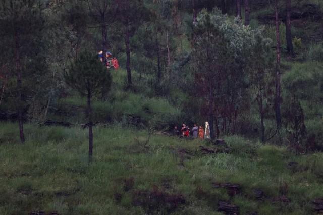 Families take shelter on higher ground, following a storm that caused heavy rains and flooding in Bayshonai Kalay, in Buner district, in Khyber Pakhtunkhwa province, Pakistan, August 18, 2025. REUTERS/ Akhtar Soomro