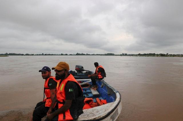 Members of the Rescue 1122 team sit on a boat as they wait for residents to evacuate, as the monsoon rains raise the water level of the Sutlej River, in Ghatti Kalanjar village near the Pakistan-India border in Kasur district of the Punjab province, Pakistan, August 24, 2025. REUTERS/ Akhtar Soomro