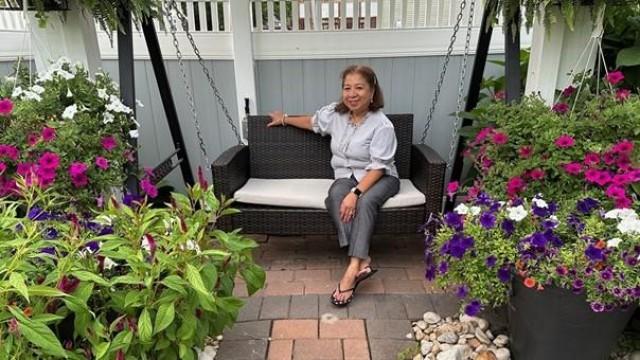 Joyce at home nestled within her flower garden. Photo by: The FilAm