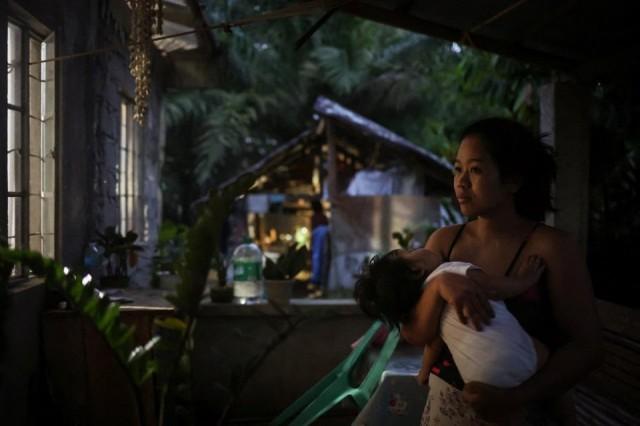 Marian Duhapa holds her baby at their family home in Irosin, a day before leaving for Taiwan to find work, March 15, 2025. REUTERS/ Ann Wang