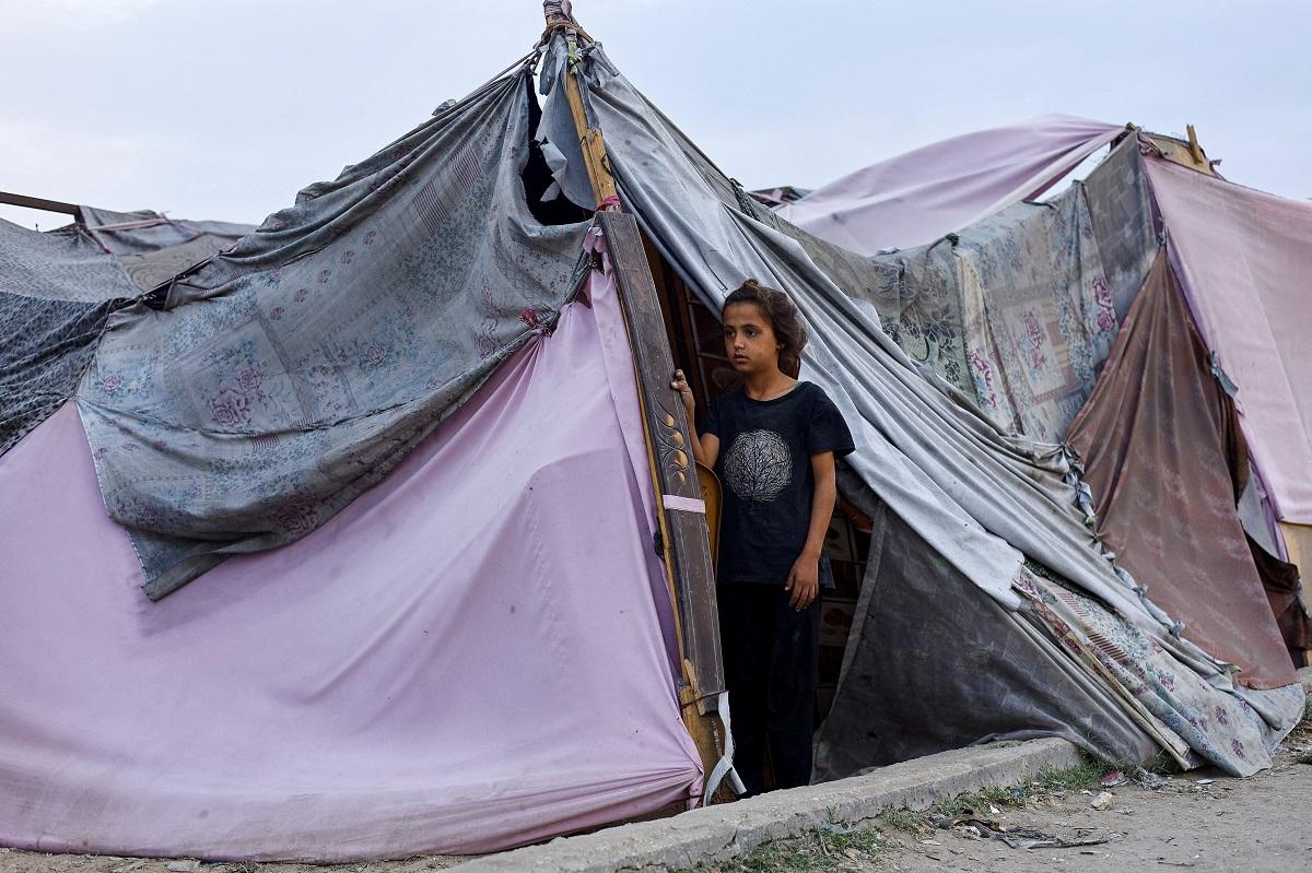 A displaced Palestinian girl looks out of a tent in Gaza City, November 4, 2025. REUTERS/ Mahmoud Issa