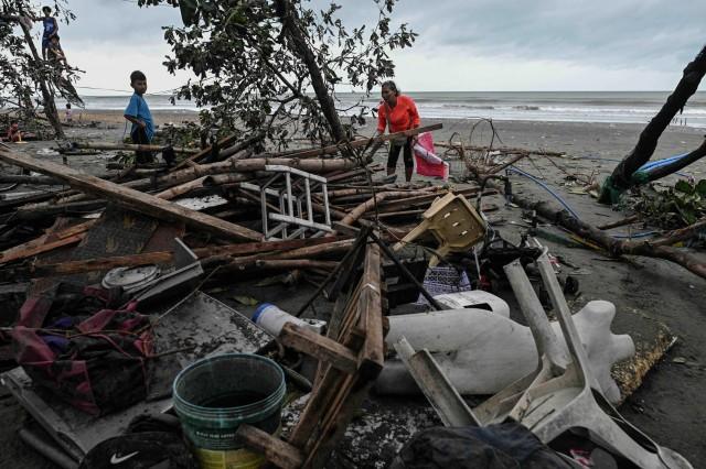 A woman returns to check her house damaged by storm surges after Typhoon Fung-wong hit the coast of Bonuan City, Pangasinan, Philippines. REUTERS/Noel Celis