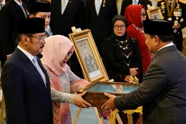 Indonesia's President Prabowo Subianto gives a plaque to Siti Hardijanti Rukmana, daughter of the former president Suharto, as Suharto receives the title of a national hero during National Heroes' Day at the State Palace in Jakarta, Indonesia, November 10, 2025. REUTERS/ Ajeng Dinar Ulfiana