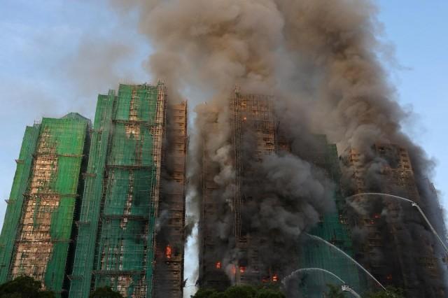 Smoke rises as flames engulf bamboo scaffolding across multiple buildings at Wang Fuk Court housing estate, in Tai Po, Hong Kong, China, November 26, 2025. REUTERS/Tyrone Siu