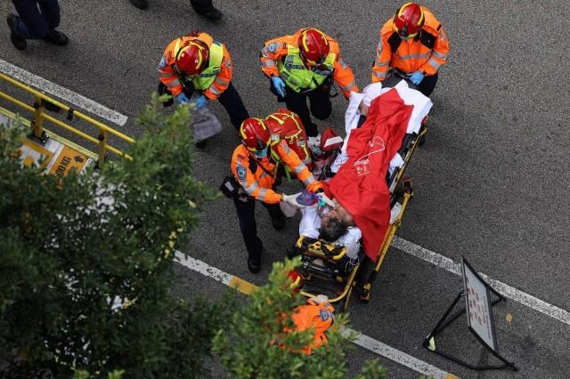 An injured resident is carried into an ambulance after a major fire engulfed bamboo scaffolding across multiple blocks at Wang Fuk Court housing estate, in Tai Po, Hong Kong, China, November 27, 2025. REUTERS/ Tyrone Siu