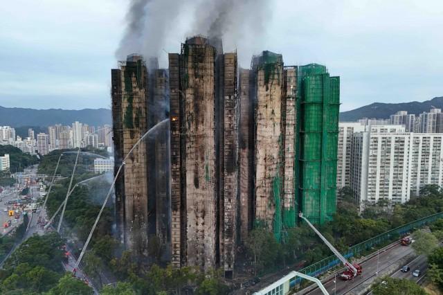 A drone view shows flames and thick smoke rising from the Wang Fuk Court housing estate during a major fire, in Tai Po, Hong Kong, China, November 27, 2025. REUTERS/Tyrone Siu