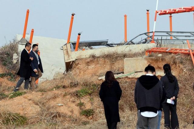 Bereaved family members walk near a concrete structure at the site of the Jeju Air crash, which claimed 179 lives, on the first anniversary of the crash, at Muan International Airport, in Muan, South Korea, December 29, 2025. Yonhap/ via REUTERS