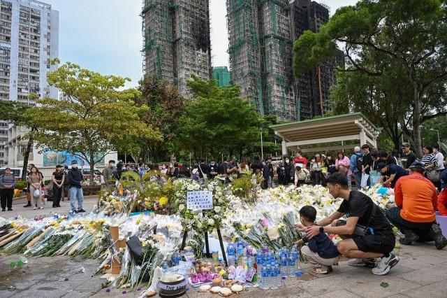 People leave flowers for the victims outside the Wang Fuk Court apartment blocks in the aftermath of the deadly November 26 fire in Hong Kong's Tai Po district on December 2, 2025. Peter Parks/ AFP