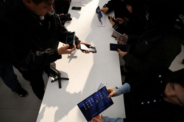 Reporters try out Galaxy Z TriFolds during an event at its store in Seoul, South Korea, December 2, 2025. REUTERS/Kim Hong-Ji