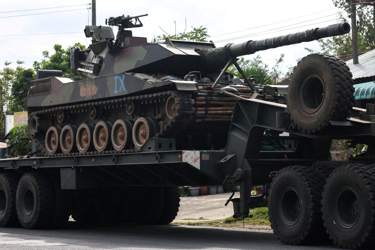 A military truck carries a tank along a disputed border area in Surin province, Thailand