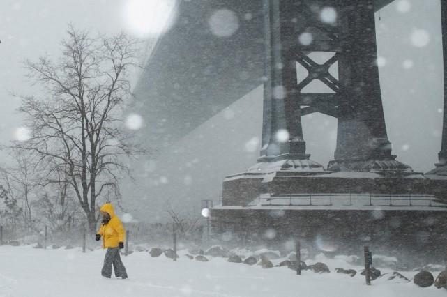 A person walks below the Brooklyn Bridge amid a major winter storm spreading across a large swath of the United States, in Brooklyn, New York City, January 25, 2026. REUTERS/ Amr Alfiky