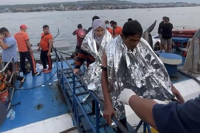 This screen grab from video footage taken and received on January 26, 2026 from Governor Mujiv Hataman shows rescuers assisting survivors of the sunken MV Trisha Kerstin 3 at a port in Isabela, Basilan. Handout/ Governor Mujiv Hataman/ AFP