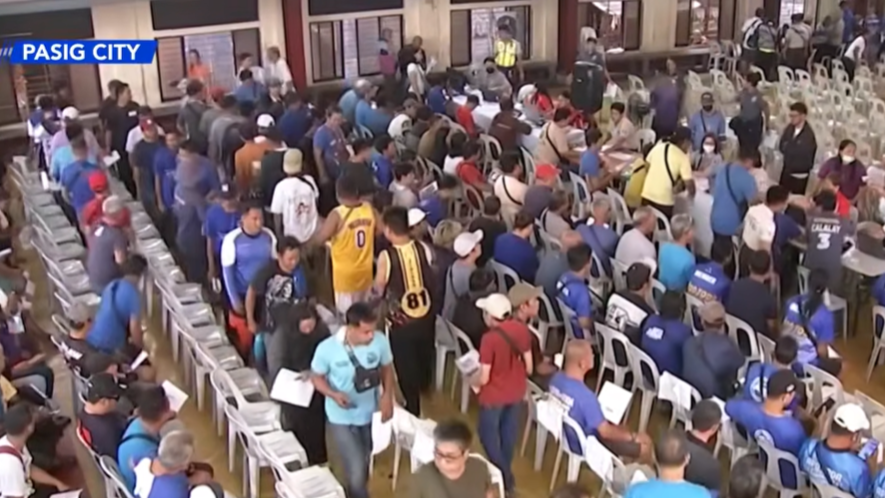 Tricycle drivers line up for the P5,000 cash aid from the government