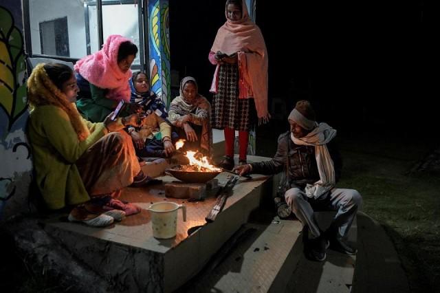 Security guard Pannelal Rajak, 78, sits with a group of women from the Shiv Shakti Mahila Gram Sangathan self help group, as his shift begins and theirs ends. REUTERS/ Avijit Ghosh