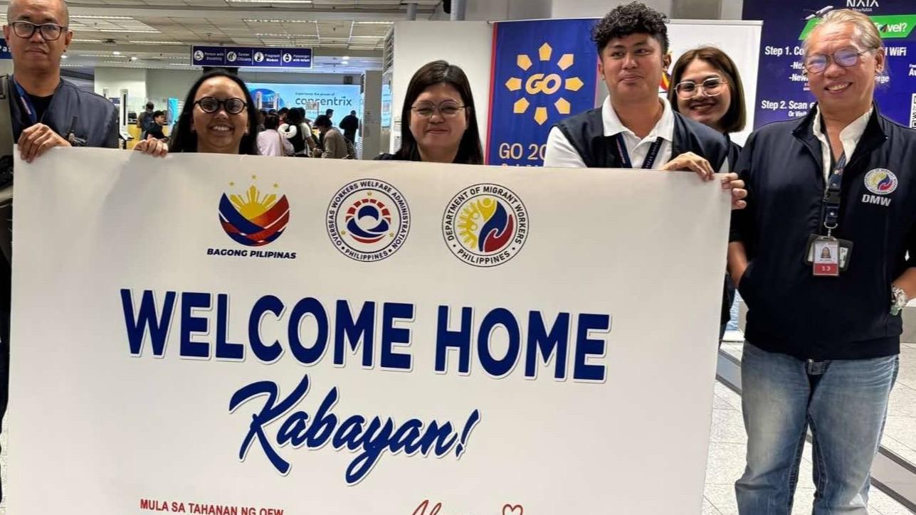 Department of Migrant Workers personnel welcome the overseas Filipino workers repatriated from Lebanon