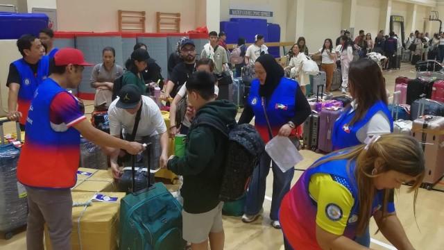 Philippine government workers assist Filipinos in line for repatriation at a processing site in Al Quasis, United Arab Emirates on Thursday, April 2, 2026. JOJO DASS