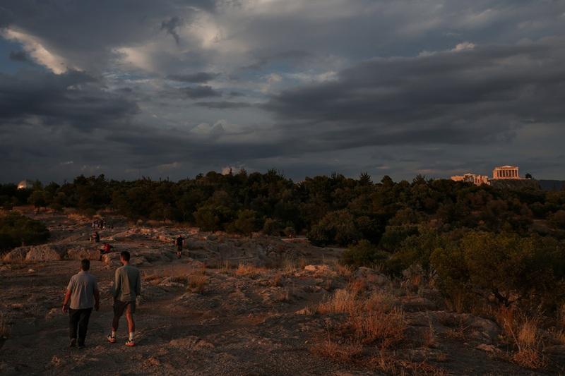 People enjoy Acropolis during sunset in Athens