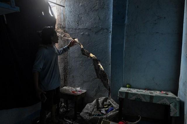 A man shows the damaged wall of a house a day after the magnitude 7.8 quake in General Santos City, June 9, 2026. REUTERS/ Noel Celis