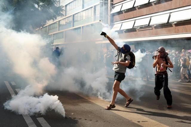 A person throws a tear gas canister, amid clashes with riot police officers during a protest against the upcoming G7 summit in Evian-les-Bains in France, in Geneva, Switzerland, June 14, 2026. REUTERS/ Denis Balibouse