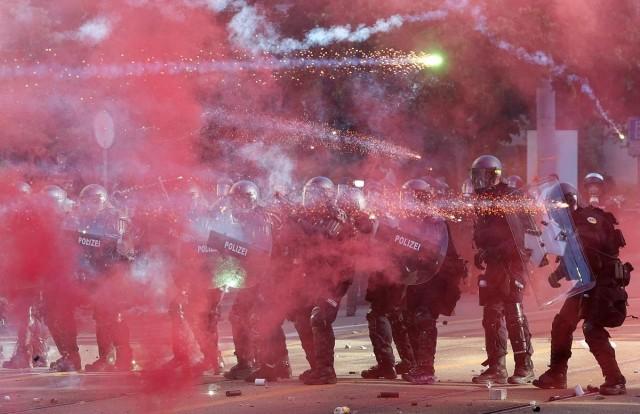 Riot police officers use shields to protect themselves, as fireworks fly in the air, during clashes with demonstrators, amid a protest against the upcoming G7 summit in Evian-les-Bains in France, in Geneva, Switzerland, June 14, 2026. REUTERS/ Denis Balibouse