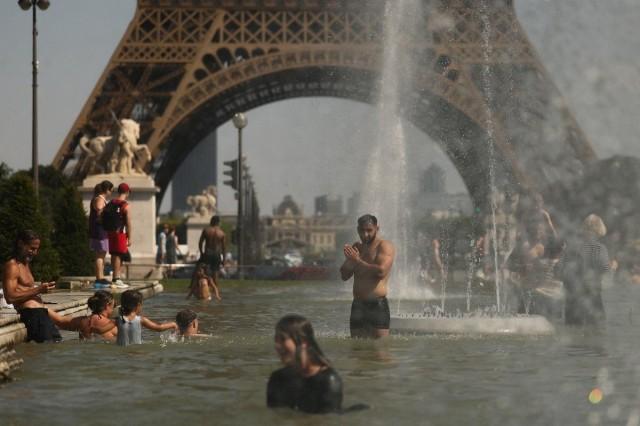 People cool off in the Trocadero Fountain near to the Eiffel Tower as temperatures rise during a heatwave affecting a large part of the country, in Paris, France, June 24, 2026. REUTERS/ Gonzalo Fuentes