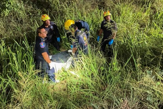 Rescue workers recover a suitcase from a grassy area near a railway track, in which police later found the body of a 17-year-old Thai girl, in Pattaya City, Thailand, June 27, 2026. REUTERS/ Teerasak Suttativong