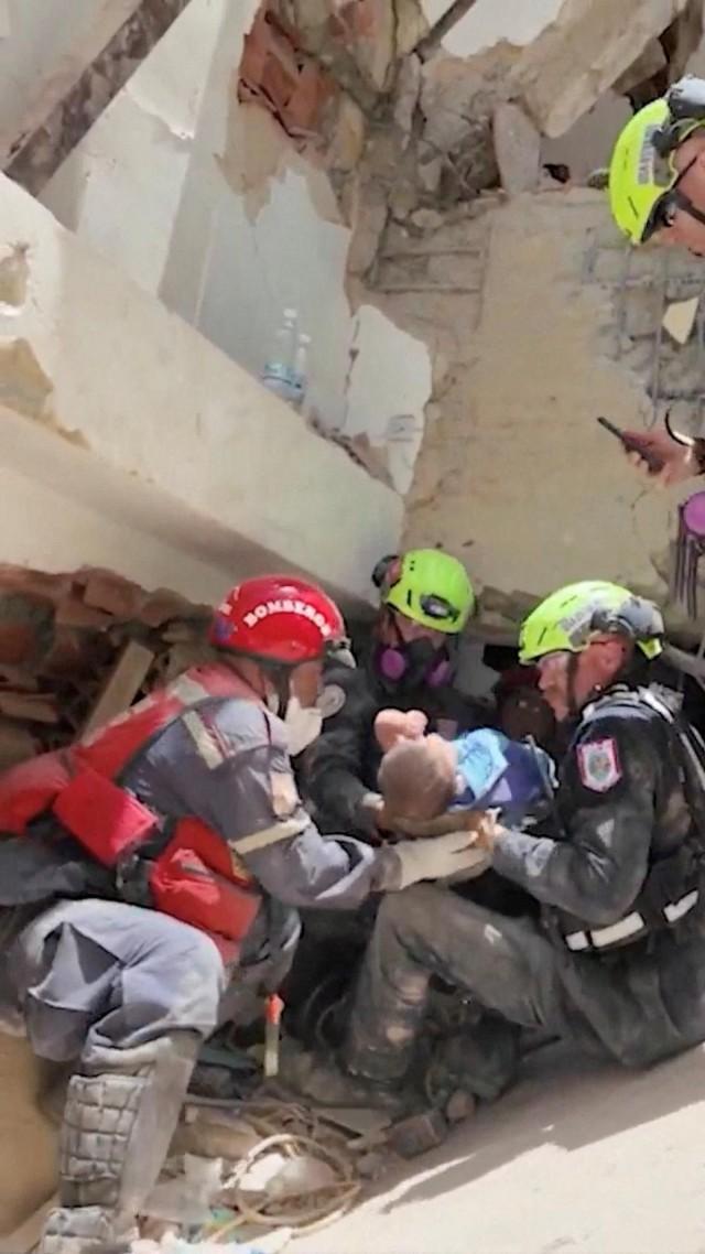 Emergency workers carry a baby rescued from the rubble in the aftermath of earthquakes, in La Guaira, Venezuela, in this still image obtained from a video released on June 27, 2026. US Department of State/ Handout via REUTERS
