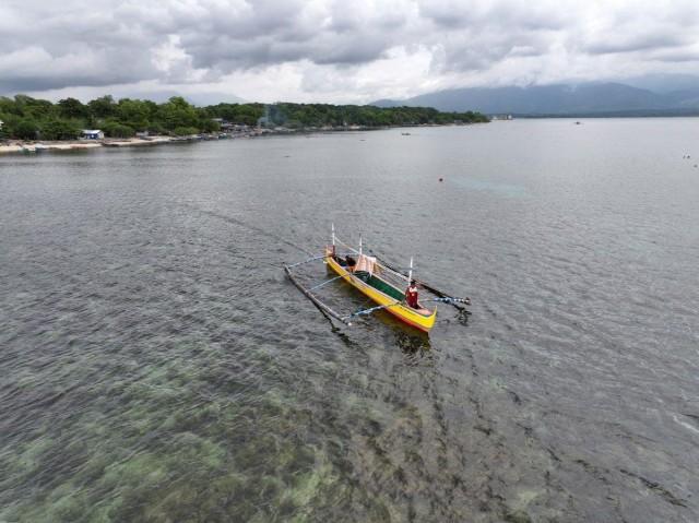A drone view shows 59-year-old Filipino fisherman Rony Drio stands aboard a small fishing boat in San Salvador, Masinloc, Zambales province, Philippines on Wednesday, July 8, 2026 ahead of the 10th anniversary of the 2016 international arbitral ruling that invalidated China's expansive claims in the South China Sea. REUTERS/Adrian Portugal 