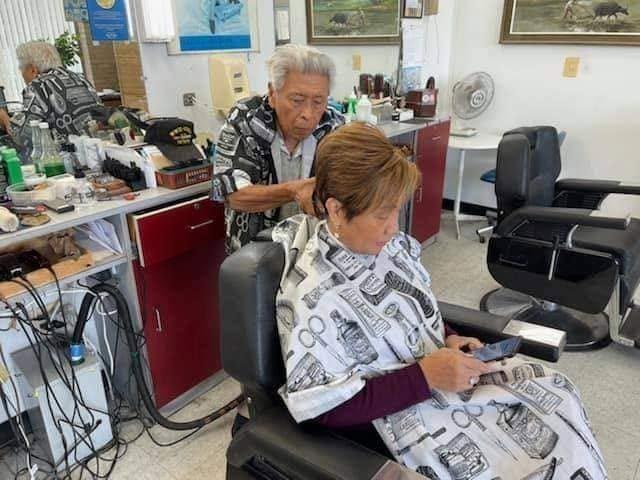 Manang Carol giving community leader and friend Bing Branigin a haircut. Courtesy Bing Branigin via The FilAm