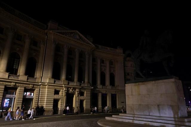 Tourists walk past the Central University Library Carol I that has its architectural outdoor lighting turned off, in Bucharest, Romania, August 5, 2026. Inquam Photos/ Octav Ganea