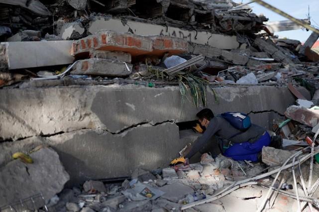 A man searches for survivors at the site of a collapsed building, in the aftermath of an earthquake, in Cali, Colombia, August 11, 2026. REUTERS/ Sergio Acero