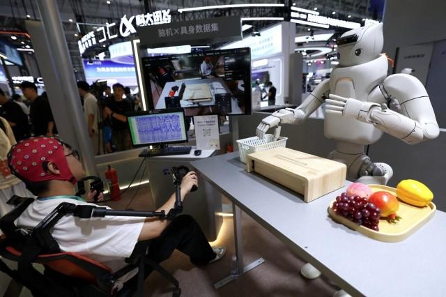 An engineer wears non-invasive brain-computer interface (BCI) head cap to pilot a humanoid robot, at the Fourier Intelligence booth during the 2026 World Robot Conference, in Beijing, China August 19, 2026. REUTERS/ Tingshu Wang