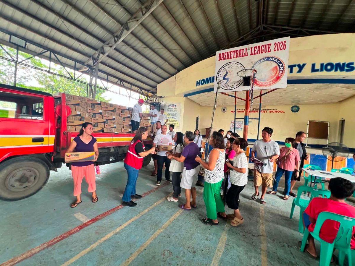 DSWD personnel hand out family food packs in Sta. Barbara, Pangasinan