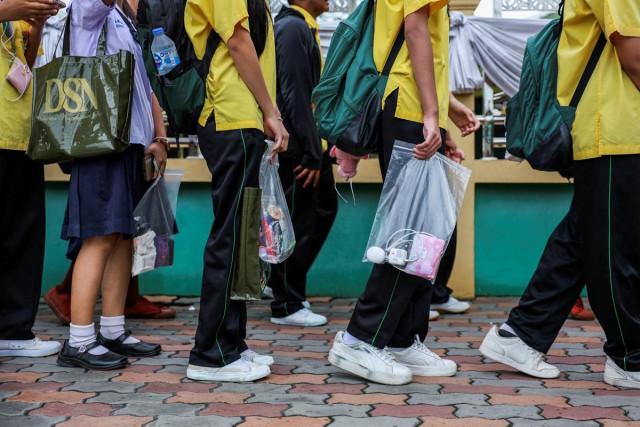 Students carry their belongings in transparent plastic bags as they enter Debsirin Nonthaburi School following its temporary closure after a deadly shooting in Bang Kruai district, Nonthaburi province, on the outskirts of Bangkok, Thailand, September 1, 2026. REUTERS/ Valeria Mongelli