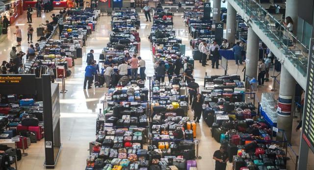 Passengers queue to claim baggage from Thai Airways flights at Suvarnabhumi International Airport, after heavy rain and flooding disrupted the airline's ground operations, in Bangkok, Thailand, September 29, 2026. REUTERS/ Athit Perawongmetha