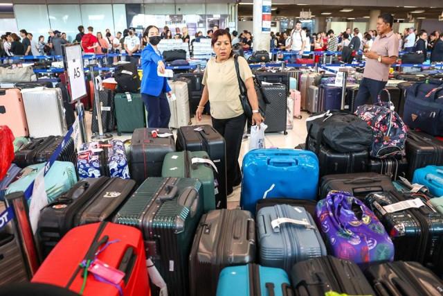 Passengers search their delayed baggage from Thai Airways flights at Suvarnabhumi International Airport, after heavy rain and flooding disrupted the airline's ground operations, in Bangkok, Thailand, September 29, 2026. REUTERS/ Athit Perawongmetha