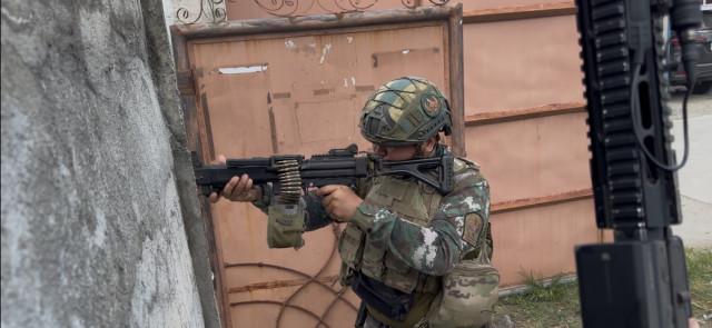 SAF member fires a machine gun in an effort to thwart the advance of the armed group.