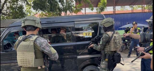 Cops stop at gunpoint a speeding mini van loaded with passengers along the main road of the town of Shariff Saydona Mustapha.