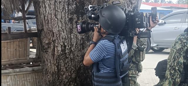 GMA News cameraman Joseph Salazar takes cover behind a tree while filming the gunbattle.