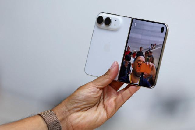 A person holds the new foldable iPhone Duo during Apple's event at the Steve Jobs Theater in Cupertino, California, US, September 9, 2026. REUTERS/Carlos Barria