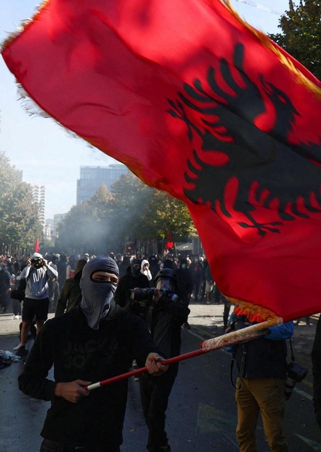 A person waves an Albanian flag, amid an anti-government protest by students, in Tirana, Albania, October 14, 2026. REUTERS/ Florion Goga