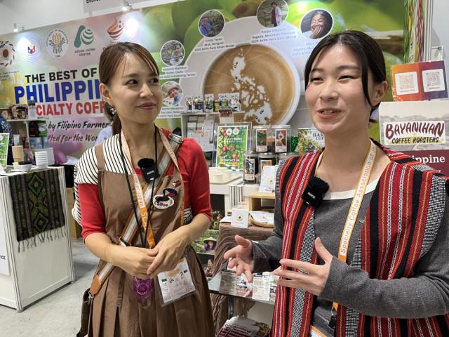 Sachiko Sata (left) of ST Lala, which imports Philippine coffee, and Kurumi, a Japanese student of Philippine studies, join activities at the Philippine booth during SCAJ 2026, where Japanese participants were introduced to Philippine coffee origins, varieties and different ways of appreciating the beans. Photo: Jay-vee Marasigan Pangan