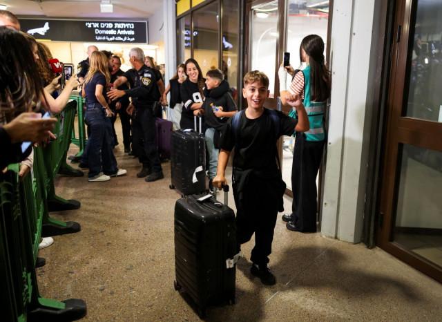 A boy cheers while holding luggage as passengers who were on the FlyDubai aircraft bound for Israel from the United Arab Emirates, which was diverted to Saudi Arabia following an emergency signal, arrive at the Ben Gurion International Airport, in Lod, near Tel Aviv, Israel, September 30, 2026. REUTERS/Ammar Awad